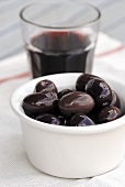 A small bowl of Kalamata olives and a glass of wine