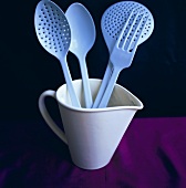 Fork and spoons in measuring jug
