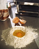 Heap of flour with egg broken into it