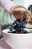 Tipping fresh berries into a bowl