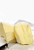 A block of butter and knife on paper
