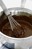 Melted chocolate in a pan with a whisk