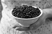 Hand holding a bowl of espresso beans