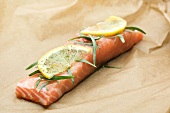 A piece of salmon fillet with tarragon and lemon slice