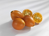 Vier Kumquats, eine halbiert