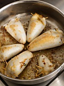 Frying stuffed squid in a frying pan