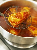 Frying stuffed squid in a frying pan