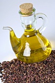 Grape seed oil in a glass bottle with grape seeds