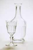 A glass of water with carafe in background