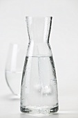 A carafe of mineral water, glass in background