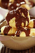 Profiteroles with chocolate sauce in a small bowl