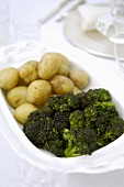 Purple broccoli & boiled potatoes (unpeeled) on a platter