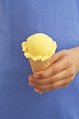 Hand holding a vanilla ice cream cone