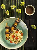 Beef and pineapple skewers with noodles and tomatoes