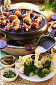 Raclette with sausages, meatballs and vegetables