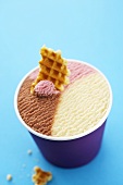 Neapolitan ice cream in tub with waffle