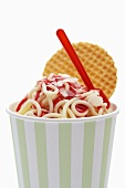 Ice cream spaghetti in tub with wafer and plastic spoon