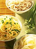 Three different types of cooked noodles in three bowls