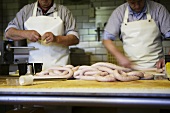 Two butchers making sausages