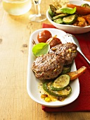 Meat patties with sweetcorn on roasted vegetables