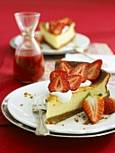 Two pieces of cheesecake with fresh strawberries