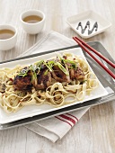 Asian chicken on noodles and mushrooms