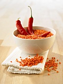 A bowl of red lentils with two chillies