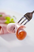 Ham roll speared on a fork
