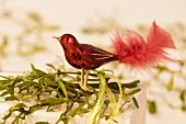 Red glass bird on a parcel decorated with mistletoe