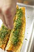 Sprinkling fish fillets with herbs and seasonings