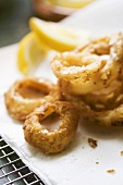 Deep-fried onion rings with lemon wedges