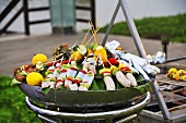 Barbeque kebabs with squid, fruit, vegetables and sausage