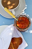 Apricot jam with a croissant and cafe au lait (seen from above)