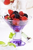 A glass bowl filled with raspberries and blackberries