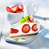 A slice of cream cheese cake with strawberries