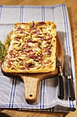 Zwiebelkuchen (onion cake) on a chopping board