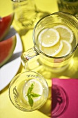 Zitronenwasser im Glas und Krug