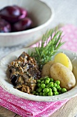 Roast lamb with aubergines, peas and potatoes