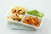 Tomato pastries, chicken fingers and watercress in a plastic box