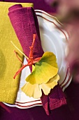 Place setting decoration with a serviette and yellow gingko leaves