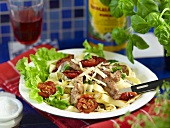 Tagliatelle salad with strips of pork and cherry tomatoes