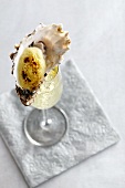 An oyster au gratin in a champagne glass