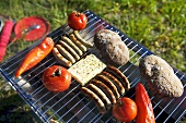 Sausages, cheese and vegetables on a barbeque