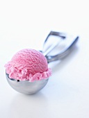 A scoop of raspberry ice cream in an ice cream scoop