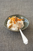 Carrot quark dip in a small dish with a spoon