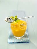 Ein Glas Ananas-Cocktail mit Schlagsahne auf einem Löffel
