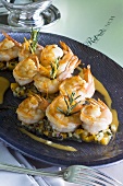 Fried prawns with rosemary on vegetables and orange sauce