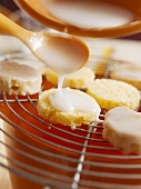 Pouring orange icing over sponge rounds