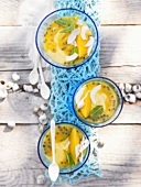 Three bowls of mango mousse with passion fruit out of doors