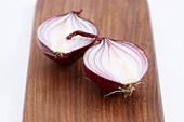 A halved red onion on a wooden background